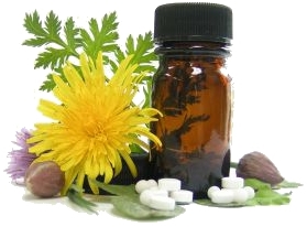 Naturmedizin: ein gelbe Blüte mit einigen grünen Blättern dahinter liegt links neben einer kleinen, braunen Medikamentenflasche, davor auf kleinen Blättern sind einige kleine Tabletten (vermutlich Schüsslersalze)